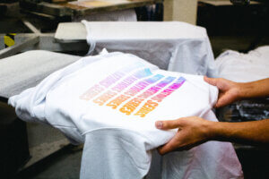 An image of a designer examining a printed t-shirt sample