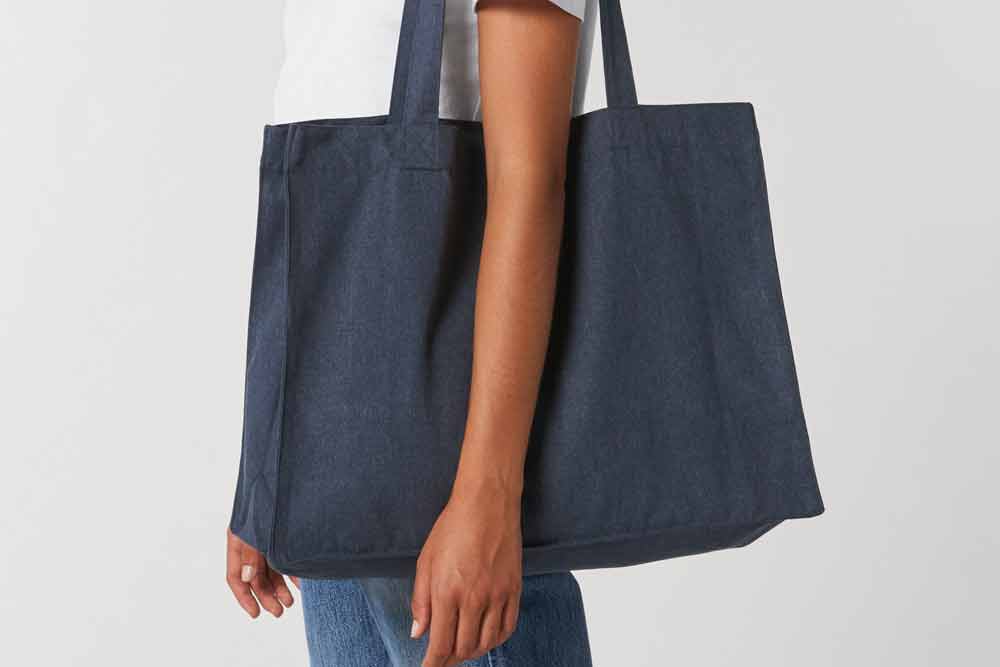 Woman holding a bag perfect for custom printing, showcasing style and versatility.