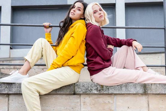 2 women wearing Continental Clothing joggers, perfect for custom printing, showcasing sustainability and comfort.