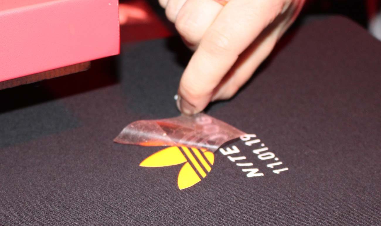 DTF transfer being applied to a garment during custom printing production