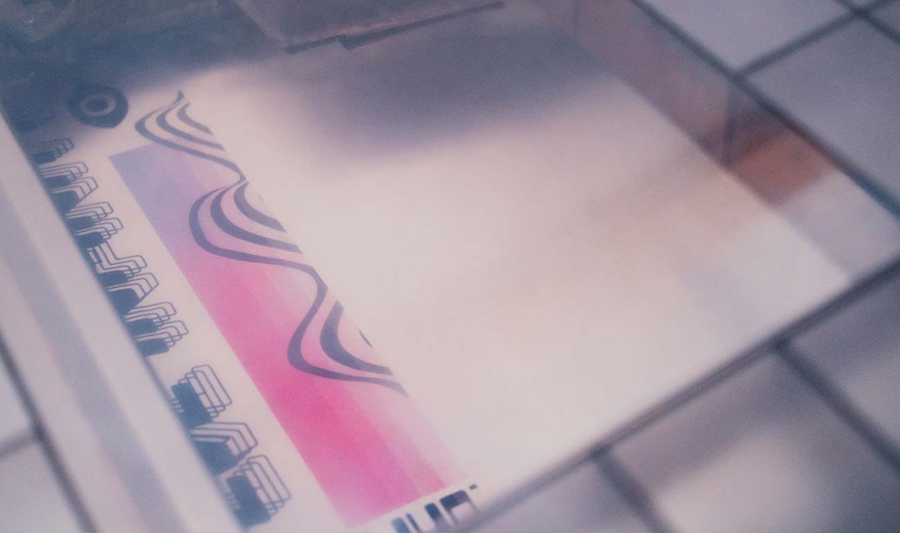 Close-up of DTG printer applying detailed artwork onto white cotton t-shirt