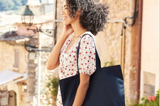 Person holding a Westford Mill bag, perfect for custom printing, showcasing sustainability and style.